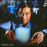 Scientist Peter Tsou holding a cube of Solid Smoke aerogel.
